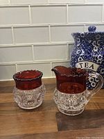 Front view creamer and sugar showing ruby band and thumbprint pattern