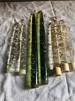All seven lucite taper candles arranged by type and size on cloth background