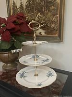 Three-tier cake stand with floral plates and gold handle