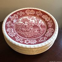 Stack of eight red and white Rusticana plates