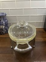 Casserole with lid in metal stand front view