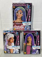 Front view of all three packaged Monster High wigs