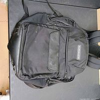Front view of black Alphalete backpack showing logo and pocket layout