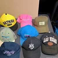 All eight hats laid out showing fronts and colours