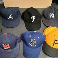 Six baseball caps arranged for overview