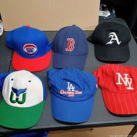 All six caps arranged top and bottom rows showing front logos and colours