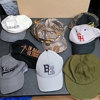 Seven hats laid out on table showing variety