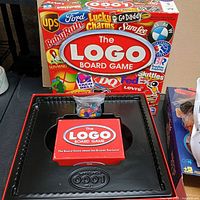Front of The Logo Board Game box with interior plastic tray and bag of pieces