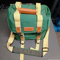 Front view of green Canon camera bag showing straps and logo