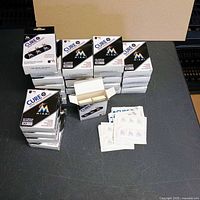 Top view of 25 Cure It Miami Marlins bandage boxes stacked with one open to show interior packaging