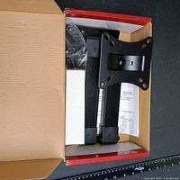 Open box showing black articulating arm and hardware