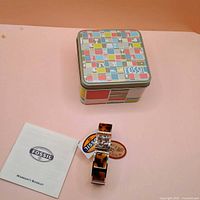 Watch, tin box and booklet overview