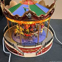 Carousel front showing figures, lighting and cord