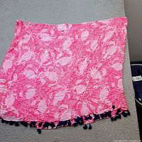 Full view of pink and white printed scarf with navy tassels