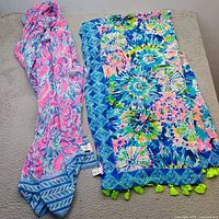 Both Lilly Pulitzer scarves laid flat showing patterns and tassels