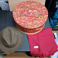 Hat, scarf, and decorative hat box on table