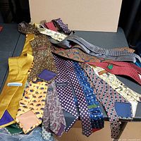 All 12 neckties spread out showing colours, patterns and labels