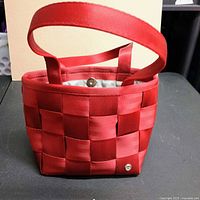 Front view of red woven Mercedes-Benz handbag