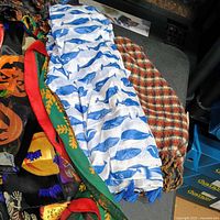 Pile showing pumpkin print scarf, whale bandana, check scarf and others