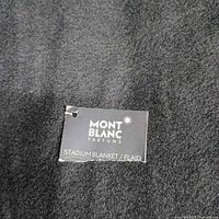 Close-up of Montblanc Parfums tag on blanket surface