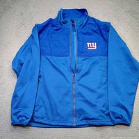 Front view of royal blue New York Giants jacket showing full length zipper and logo