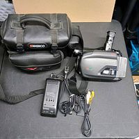 Camcorder, charger, cables and Ambico bag on table