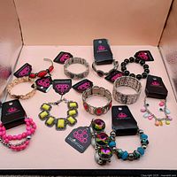 All 12 bracelets laid out showing variety of styles and tags