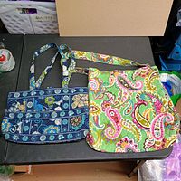 Green paisley crossbody and blue floral shoulder bag overall view
