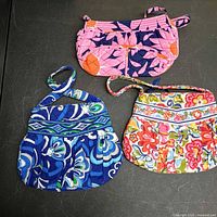Three Vera Bradley quilted handbags displayed
