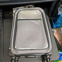 Front view of grey crocodile-pattern rolling suitcase