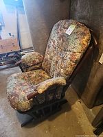 Full view of glider rocking chair showing wooden frame and floral cushions