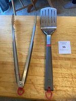 tongs and spatula full view on cutting board