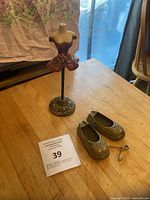 Overview showing doll stand, pair of brass slippers, wall hanger