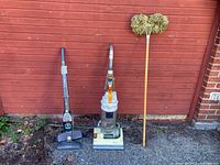 Three cleaning items lined up: Dyson upright vacuum, Electrolux Ergorapido stick vacuum, string mop