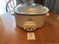 Front view showing full slow cooker with glass lid and control panel