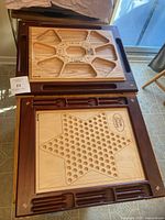 Chinese Checkers and Rummoli boards stacked, showing carved trays and playing surfaces