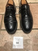 top view of pair of black leather derby shoes with shoe trees inserted