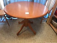 Full view of round dining table with pedestal base