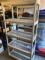 Full view of five-tier beige plastic shelving unit