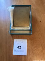 Cigarette case in open presentation box with lot card visible