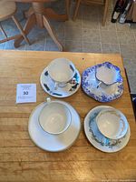 Four teacup and saucer sets on table
