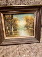 Front view of framed landscape painting showing artwork, frame detail and signature