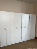 Front view of four white cabinets side by side, doors closed