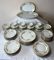 Full 51-piece Noritake Greenbriar and Topaz dinnerware set displayed