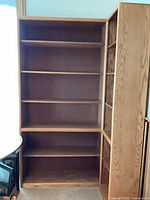 Front view of both oak bookcases showing shelves and wood grain