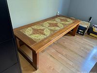 Full view of teak coffee table showing tile inlay and frame