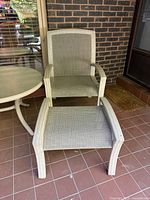 Front view of armchair and footstool on tiled patio
