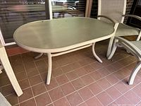 Full view of oval outdoor cocktail table on patio tile floor