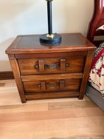 Front view of one oak nightstand showing two drawers and hardware