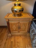 Front view of one nightstand showing top inlay, doors, column accents